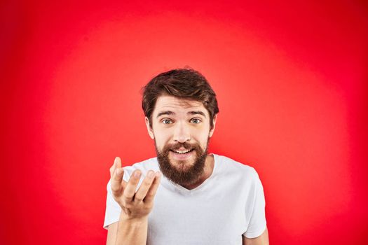Bearded man fun emotions lifestyle cropped view white t-shirt red background. High quality photo