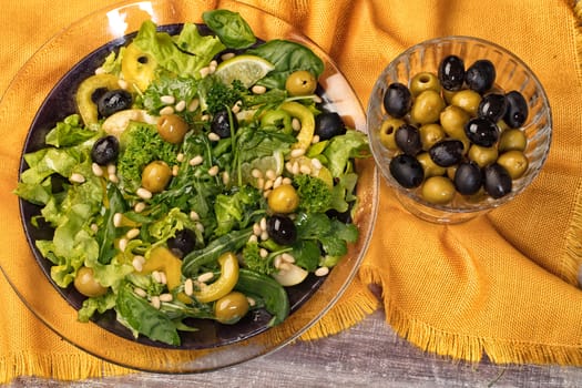 Dish of salad with olives on a fabric background