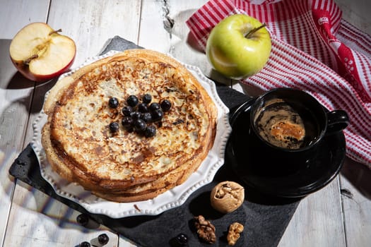 Pancakes, tea, cream and fruits on a fabric background