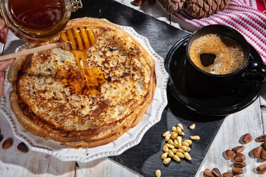 Pancakes, tea, cream and fruits on a fabric background