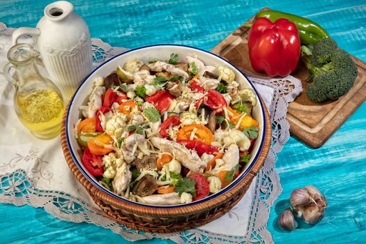 Salad with chicken and vegetables on an old wooden desk