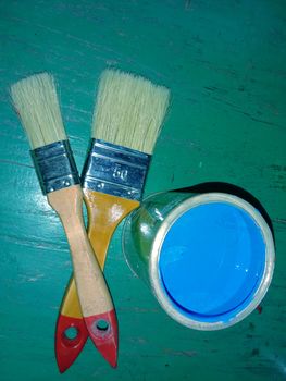 brush and blue paint in pot for painting