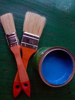 brush and blue paint in pot for painting