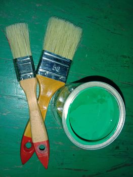 brush and green paint in pot for painting