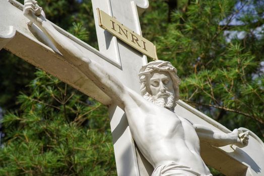 Close up of Jesus's face with arms outstretched on the cross, face turned downward at camera--with copy space.
