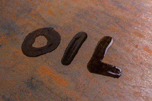 handwritten word oil on rusted sheet metal surface - close-up with selective focus conceptual photography