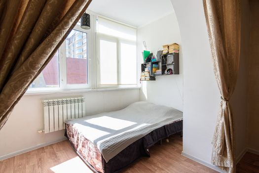 The interior of a spacious loggia in an apartment building on which a sleeping place is located