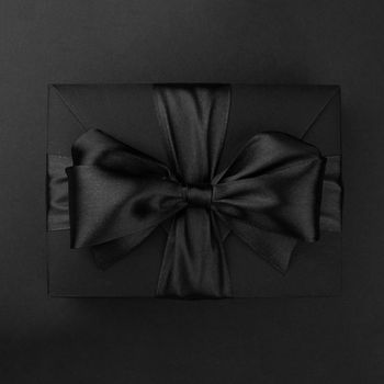 Black friday sale box gift present with ribbon bow on black conceptual design