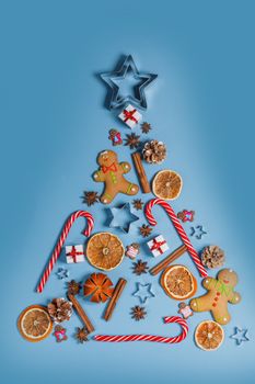 Christmas flat lay styled scene fir tree of decorations on blue background