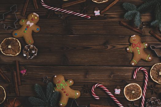 Christmas wooden background with fir tree, gingerbread cookies candy canes and decor