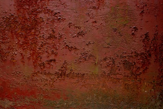 Abstract colorful image painted in red on an outdoor rotten metal