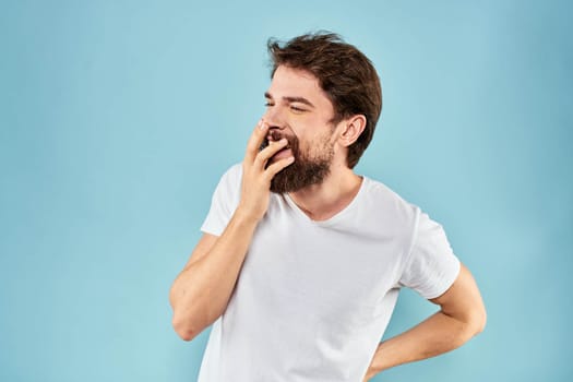 Emotional man with a beard in a white t-shirt blue background fun lifestyle. High quality photo