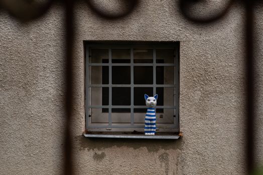 Image of a window outdoors with a fake cat for decoration