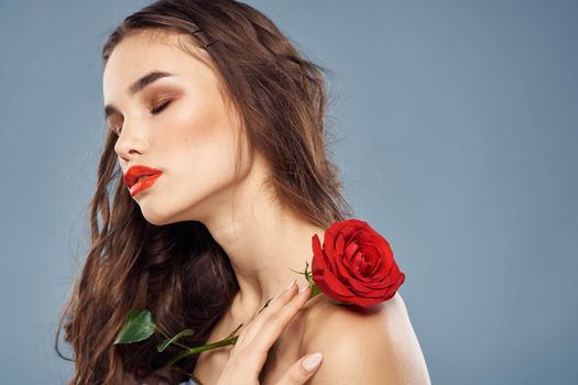 woman with a rose in her hands naked shoulders evening makeup red lips. High quality photo