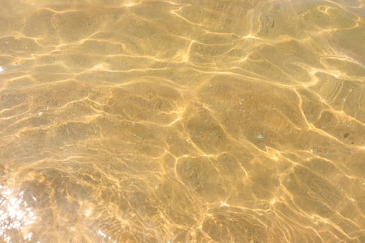 Ripples of water waves reflecting texture on a sandy beach bottom