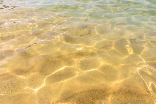 Ripples of water waves reflecting texture on a sandy beach bottom