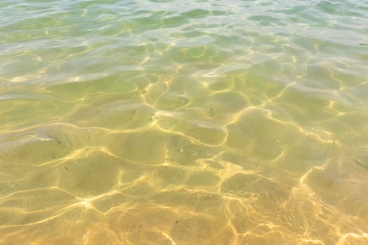 Ripples of water waves reflecting texture on a sandy beach bottom