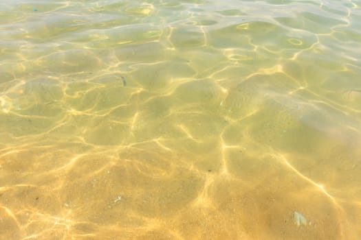 Ripples of water waves reflecting texture on a sandy beach bottom