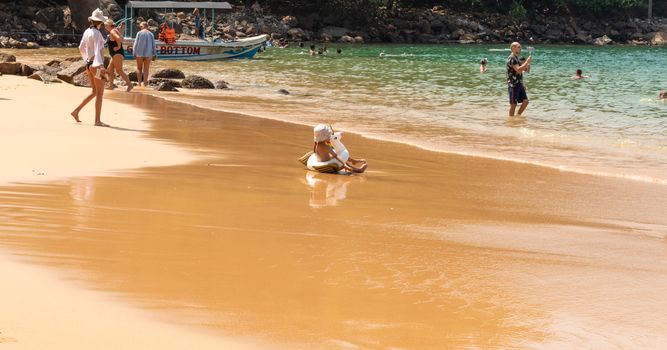 people sunbathing in Rumassala South Beach, is situated along with the Rumassala hill in Unawatuna. It is also known as Jungle Beach