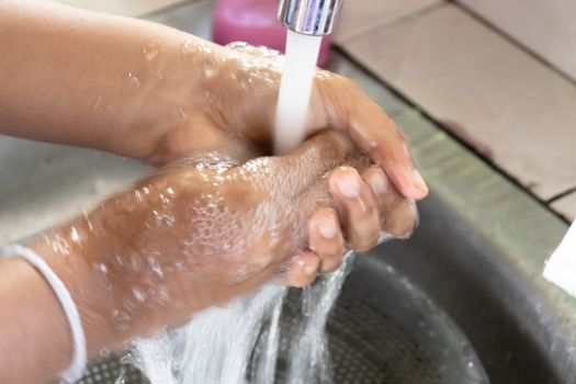 applying soap and washing with clean running water