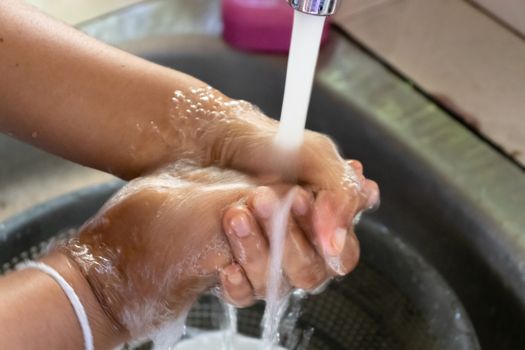 applying soap and washing with clean running water