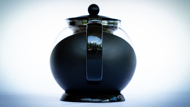 Black glass coffee pot in neutral background back side view