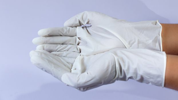 Female doctor wearing medical latex gloves in both hands together