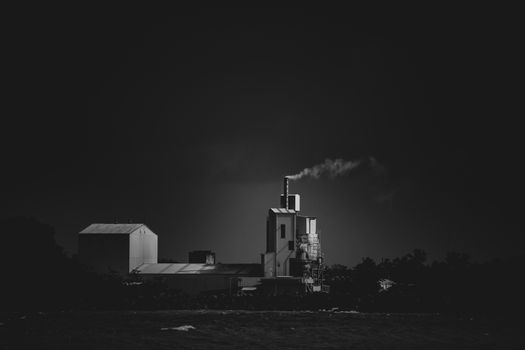 factory smoke released to the air black and white long distance photograph