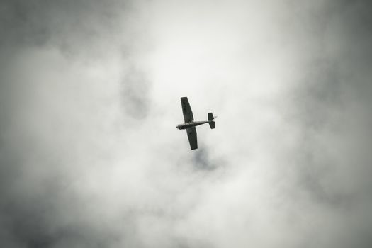 Air Plane seen from the ground long distance against dark clouds