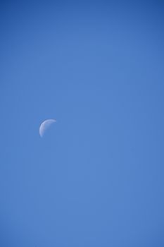 Crescent moon over cloudless, blue, blue sky, sunny