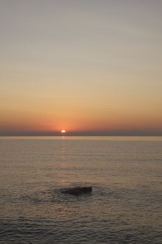 Sunrise on the rocky beach, Orange colors, lonely