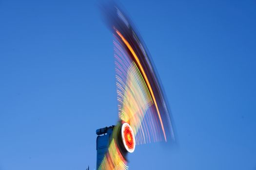 Amusement park blurred effect. Abstract illuminated background Spinning defocused carnival carousel long exposure shooting