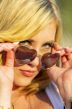 A gorgeous blonde model enjoys a summers day outdoors in a park