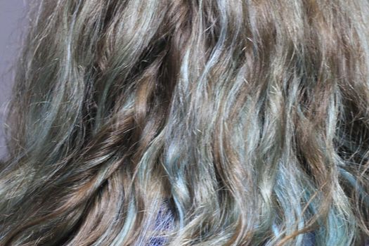 streaks of blue throughout a brunettes hair. High quality photo