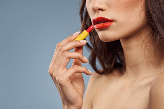Woman with lipstick on a gray background brunette makeup with eye shadow on the eyelids. High quality photo