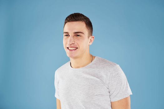 Emotional man in white t-shirt cropped view on blue background lifestyle. High quality photo