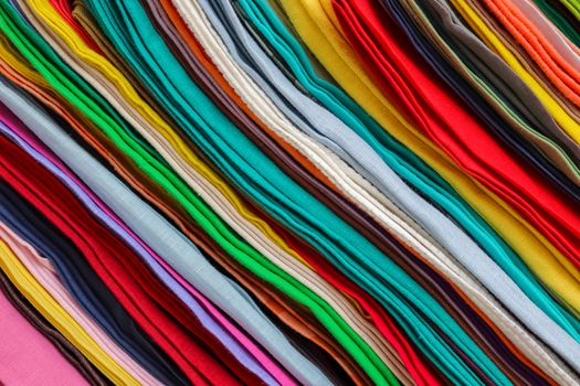 Detailed close up view on samples of cloth and fabrics in different colors found at a fabrics market.