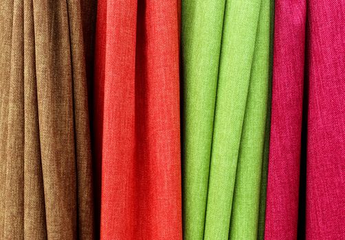 Detailed close up view on samples of cloth and fabrics in different colors found at a fabrics market.