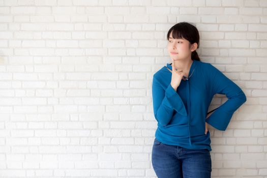 Beautiful portrait young asian woman confident thinking with cement and concrete background, girl standing expression serious or doubts with idea, lifestyle concept.