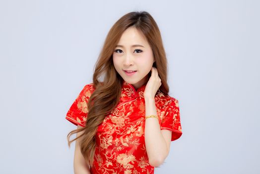 Beautiful portrait happy Chinese New Year young asian woman wear cheongsam smile with gesture congratulation and greeting isolated on white background, festival and celebrate concept.