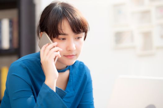 Beautiful asian young businesswoman excited and glad of success work with laptop, girl taking mobile smart phone and working coffee shop, career freelance business concept.