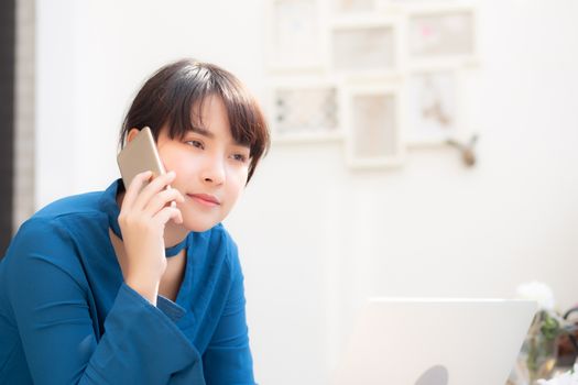 Beautiful asian young businesswoman excited and glad of success work with laptop, girl taking mobile smart phone and working coffee shop, career freelance business concept.