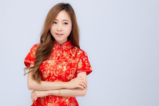 Beautiful portrait happy Chinese New Year young asian woman wear cheongsam smile with gesture congratulation and greeting isolated on white background, festival and celebrate concept.