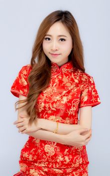 Beautiful portrait happy Chinese New Year young asian woman wear cheongsam smile with gesture congratulation and greeting isolated on white background, festival and celebrate concept.