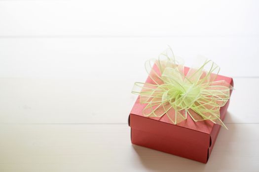 Holiday of Gift box with bow ribbon on wooden table, present of romantic day on wood, Valentine festive concept, vintage retro tone.
