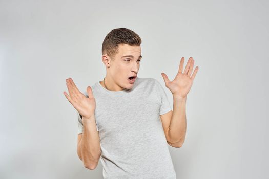 handsome man in light t-shirt cropped view emotion studio isolated background. High quality photo