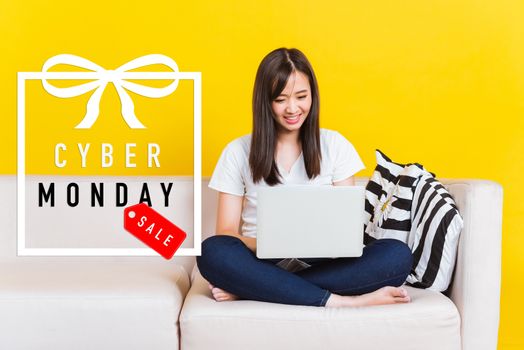 Portrait Asian of happy beautiful young woman work from home she sitting on sofa using laptop computer in house living room studio shot isolated on yellow background