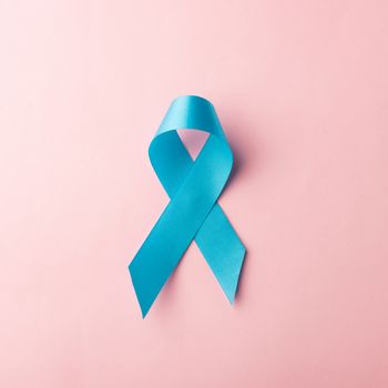 November light blue ribbon, studio shot isolated on pink background, Prostate cancer awareness month, men's health concept