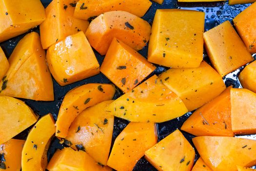 Close up of butternut squash chunks prepared for roasting, on a baking tray