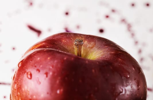 Red apple on white background ,water drops on skin , colored spots on background